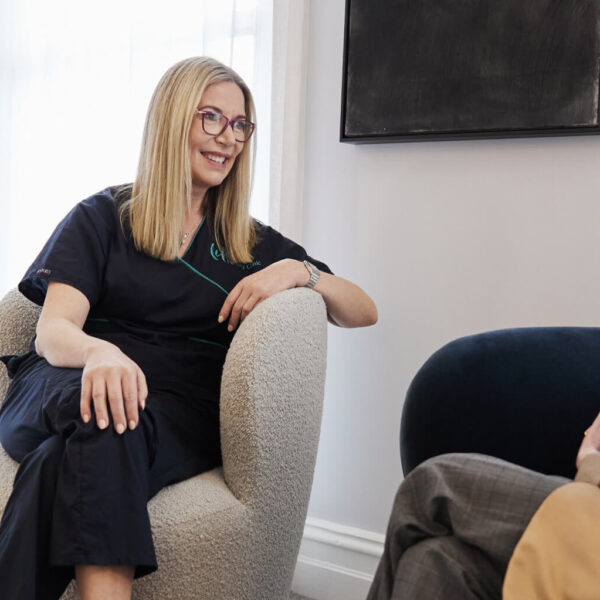 Doctor Rachael Knight is sitting on a sofa, giving a consultation to a client