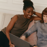 Two people researching together using one laptop computer