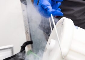 Lab technician pouring liquid nitrogen into a container