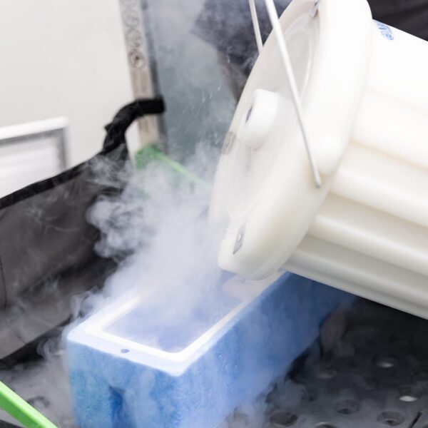 Lab technician pouring liquid nitrogen into a container