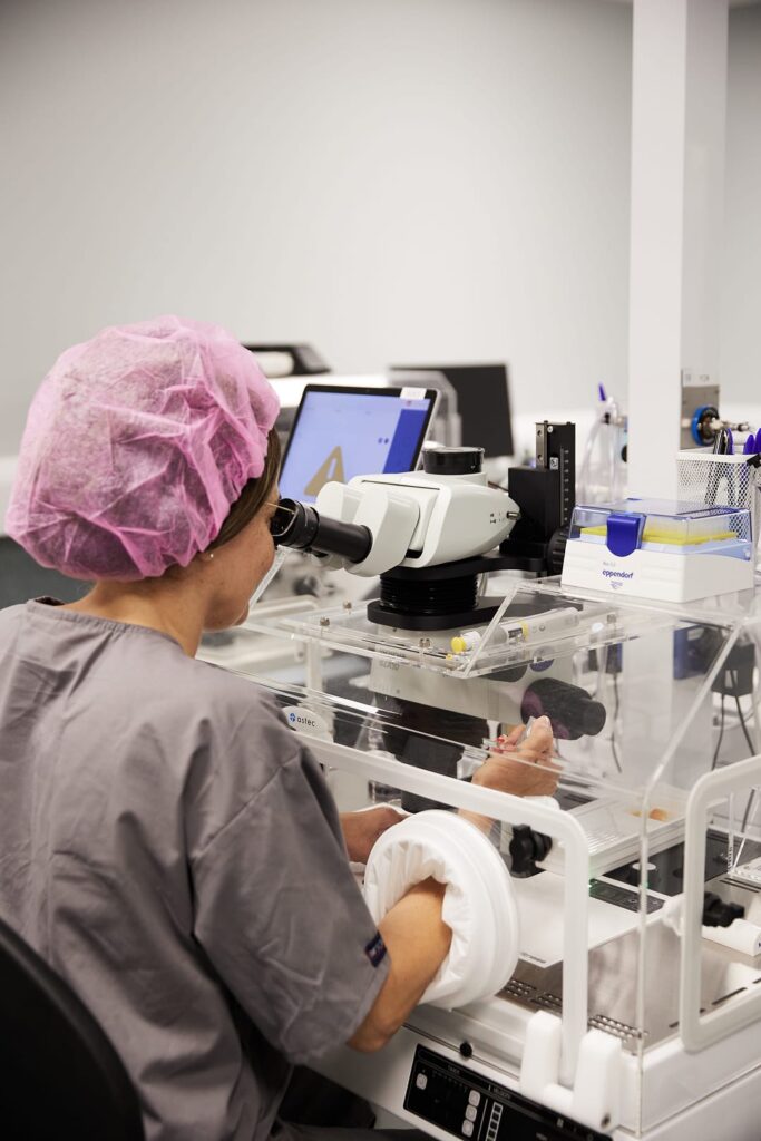Lab technician using a lab equipment while sitting down