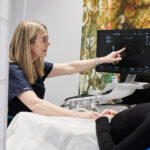 Doctor Rachael Knight sitting down performing ultrasound scan to a client
