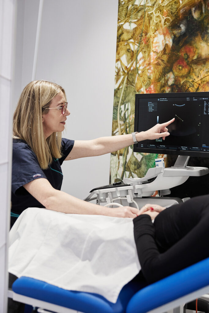 Doctor Rachael Knight sitting down performing ultrasound scan to a client