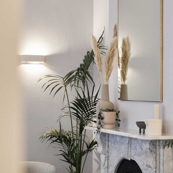 A fireplace in a living room with some decorative pots and cups