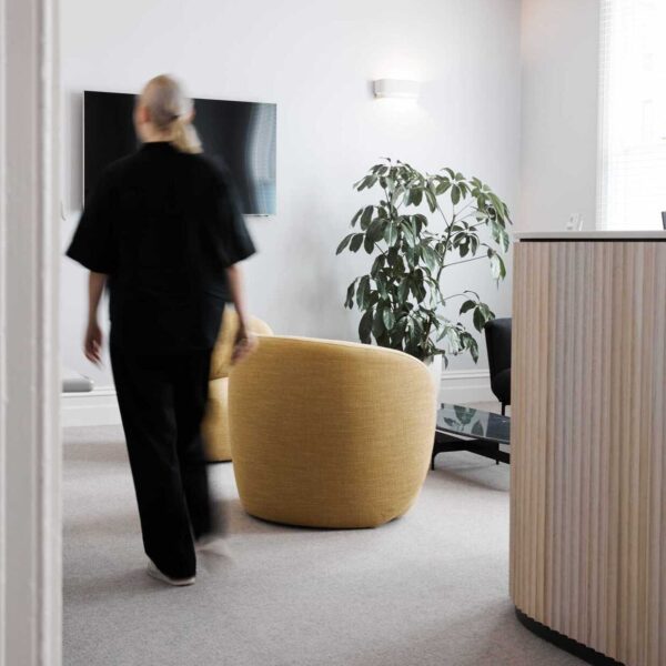 A woman walking past the reception desk in a waiting room